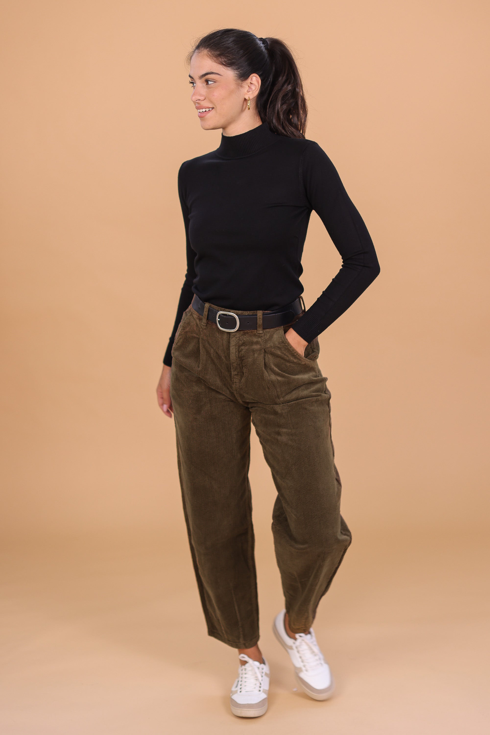 Woman wearing a black turtleneck and khaki corduroy pants