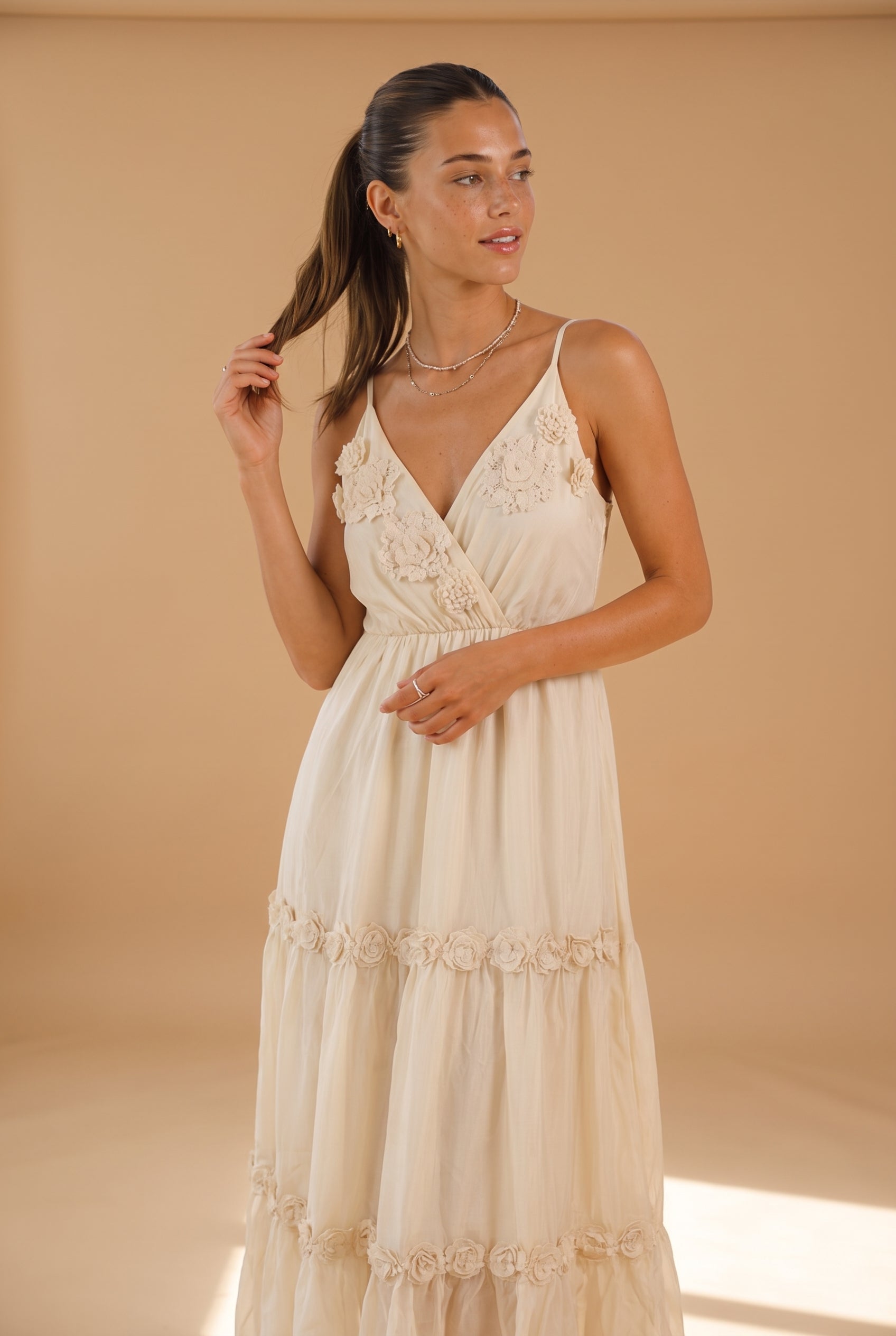 Woman wearing a beige dress against a beige background