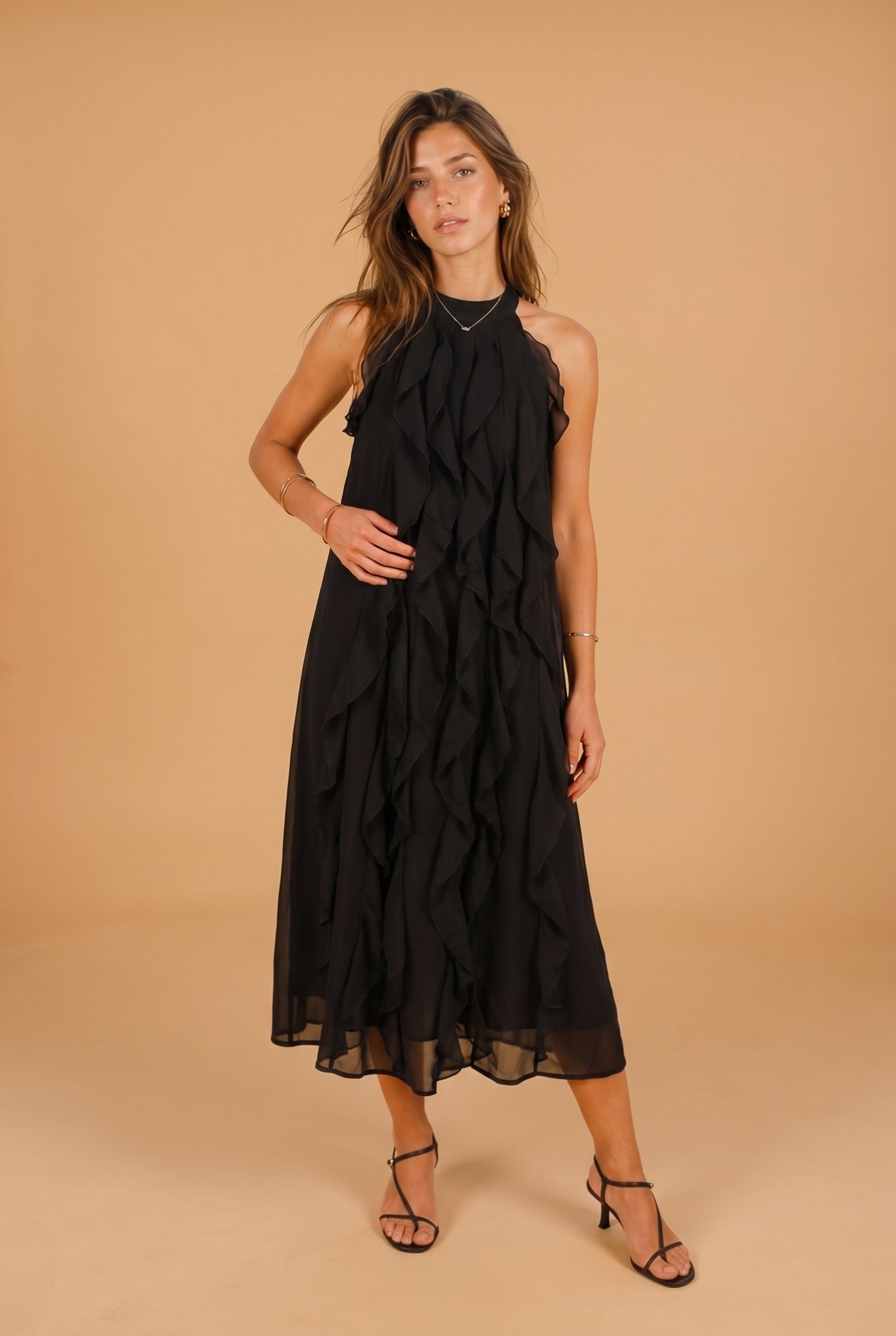 Woman wearing a black dress against a beige background